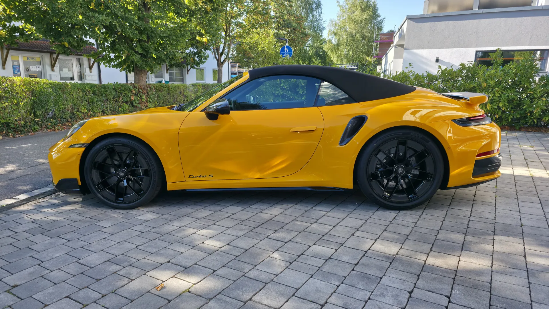 Seitenansicht eines gelben Porsche 911 Turbo S Cabriolet mit glänzendem Lack nach der Komplettaufbereitung bei GT Service München